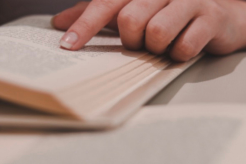 Finger pointing at words in a book